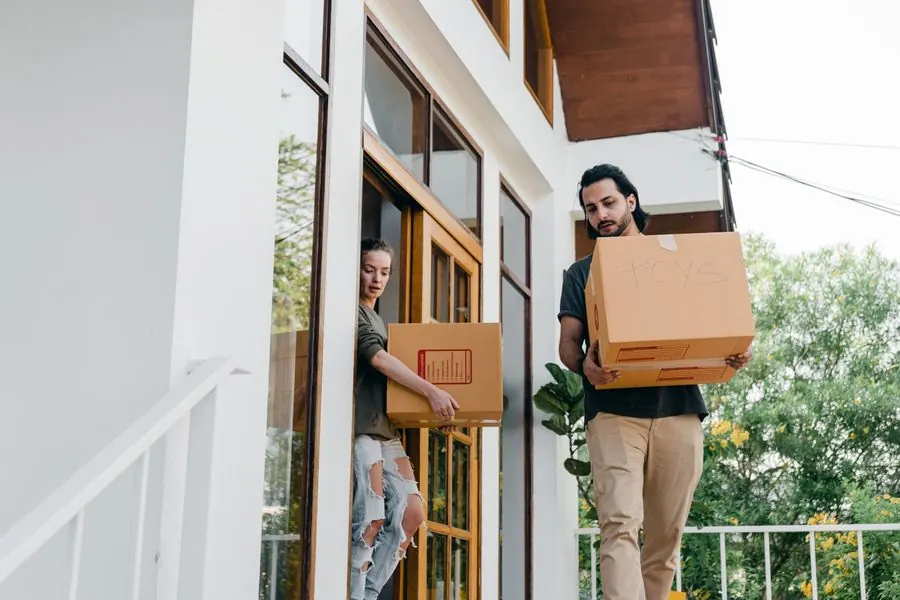 Mover carrying packed boxes out of a home