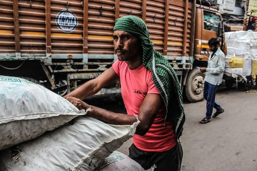 Worker loading goods onto a truck in India